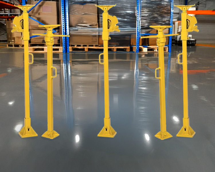 A construction worker wearing a hard hat, safety vest, and tool belt stands confidently next to a yellow featherlite ladder in a bright indoor setting.